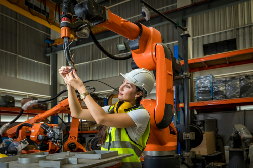 A skilled technician collaborates with advanced robotic technology to ensure precision, efficiency, and reliability in modern manufacturing operations.
