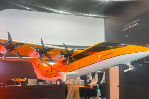 An Electra electric aircraft model on display at an aerospace industry exhibition, attracting visitors with its distinctive multi-propeller configuration and futuristic air mobility design.