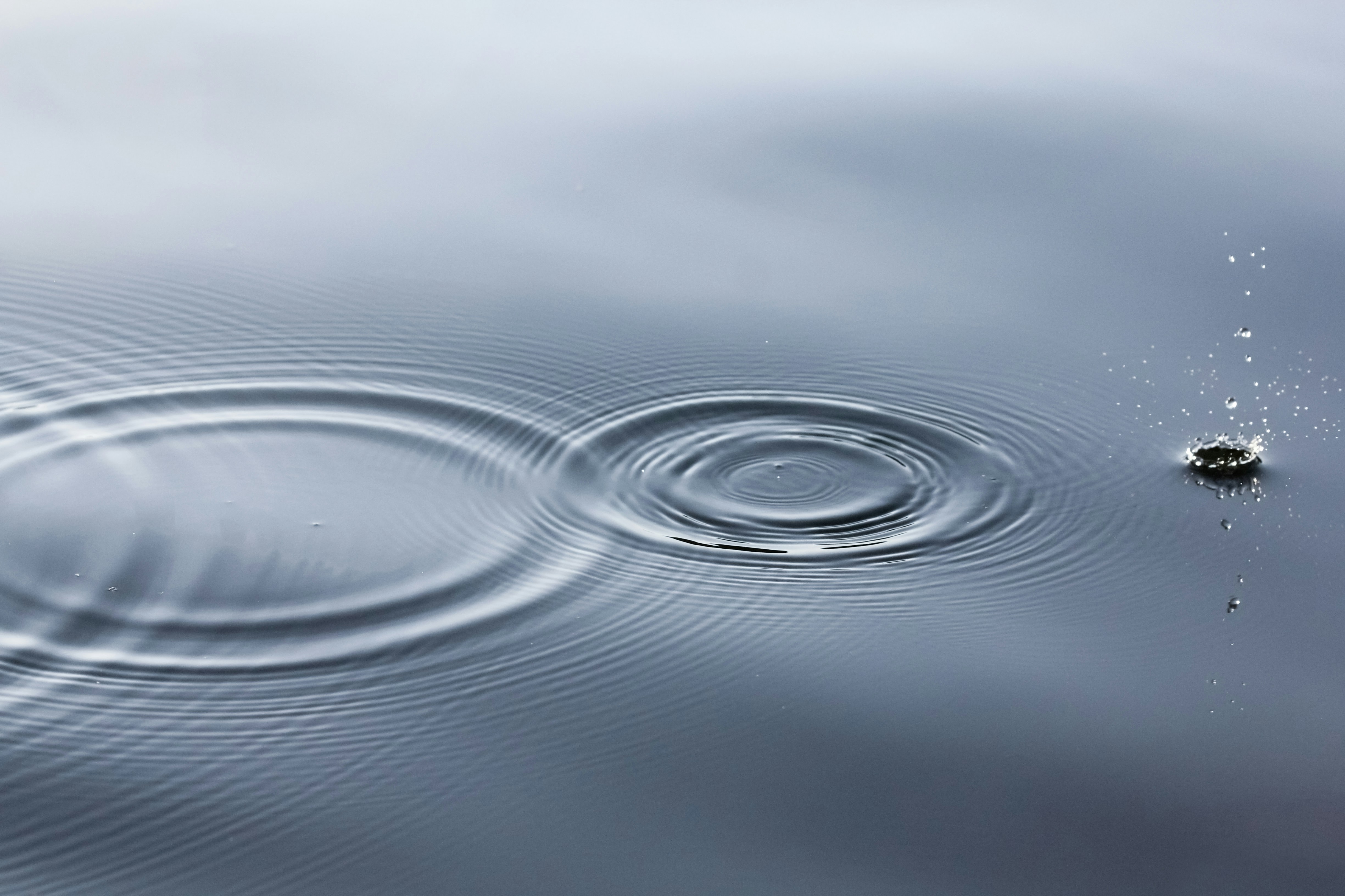Water ripples spreading outward from a single drop, symbolising the cascading impact of value chain climate action.