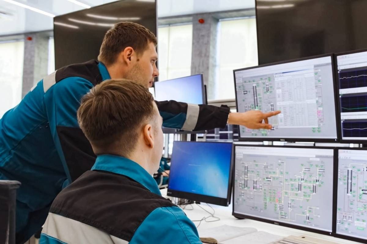 two mean looking at 2 computer screens 