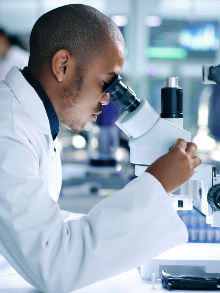 man looking into microscope