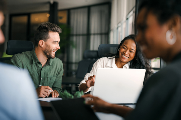Data analysts looking at 2026 salary data on laptop in office