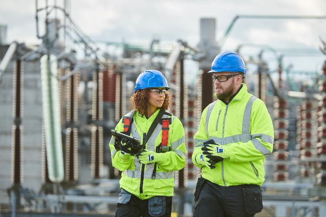 Two engineers wearing safety gear having a discussion at a site