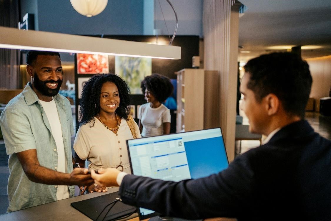 Hotel Receptionist checking in a family at the reception desk