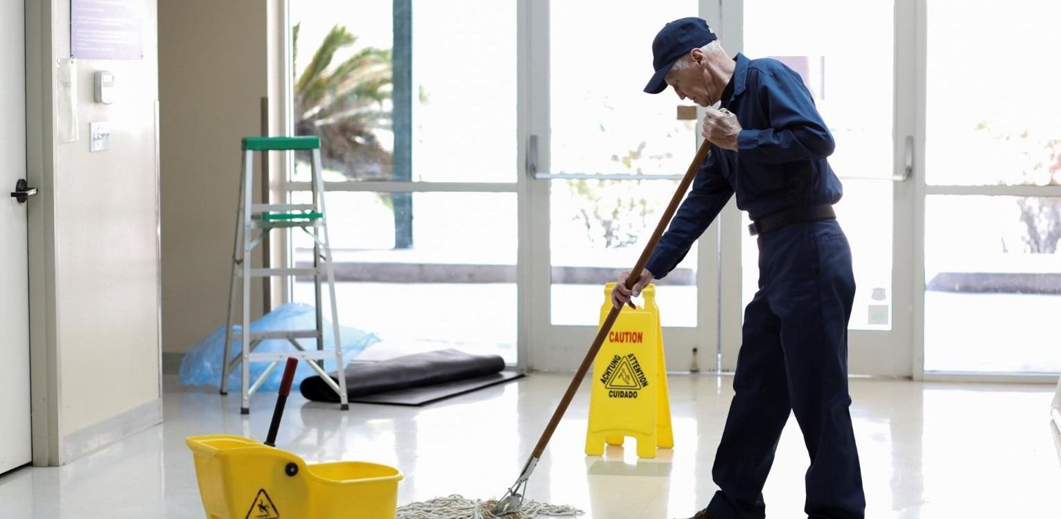 Cleaner mopping floor in university building
