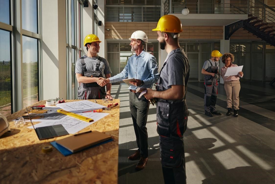 Facilities Manager shaking hands with a builder