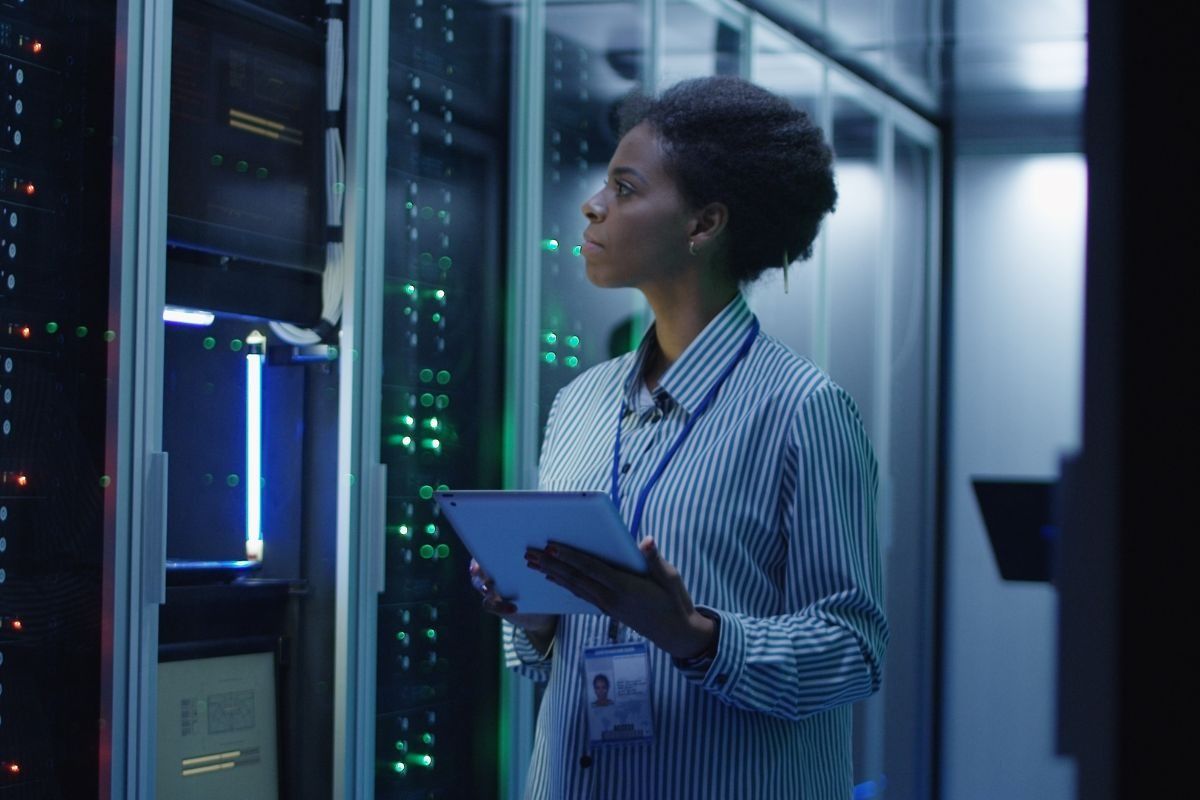 Female network technician looking at a data centre server