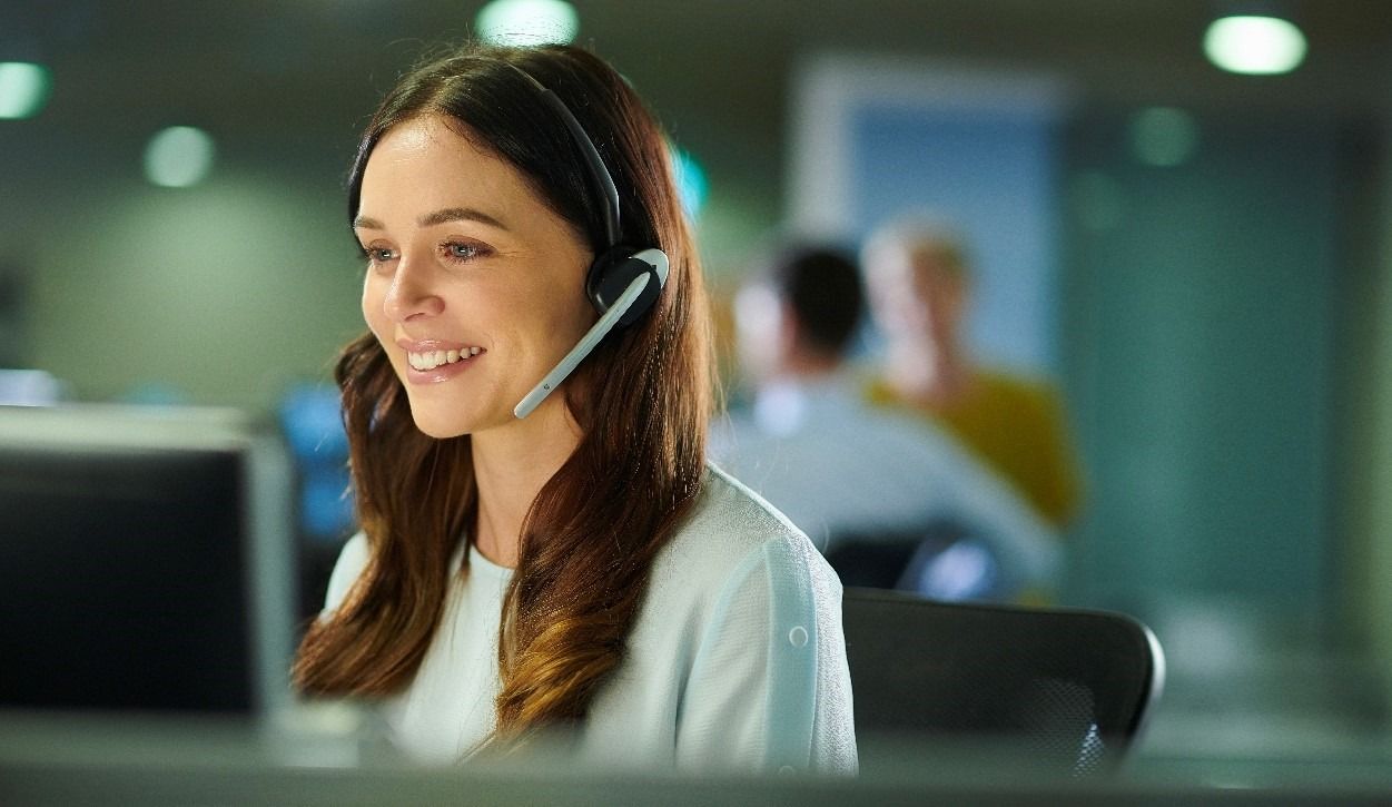 Customer service advisor on a call smiling
