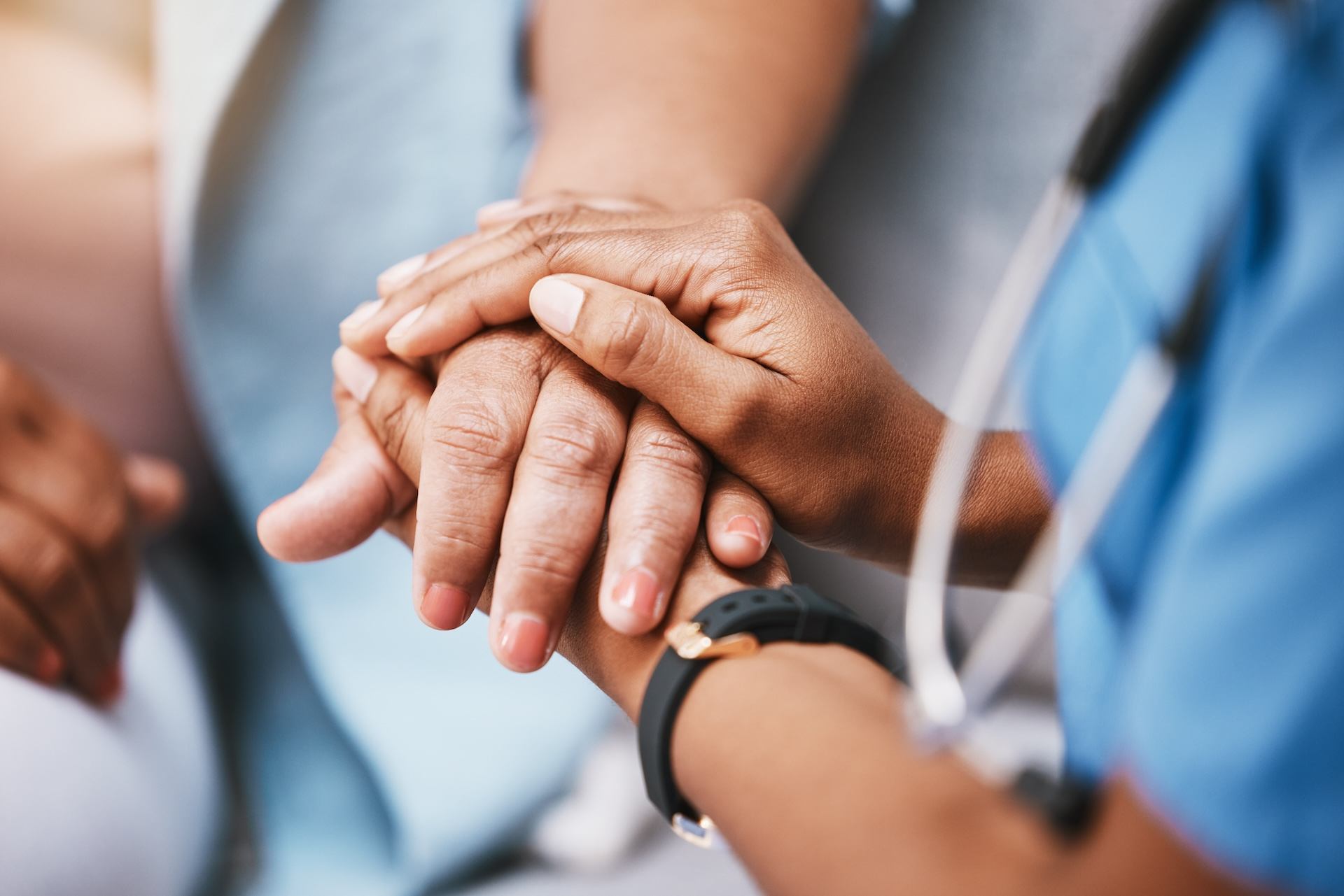 Nurse holding a patients hand
