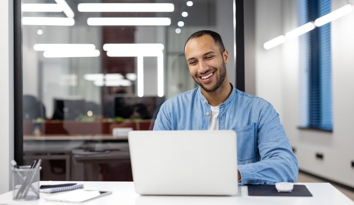 Person smiling working on a laptop