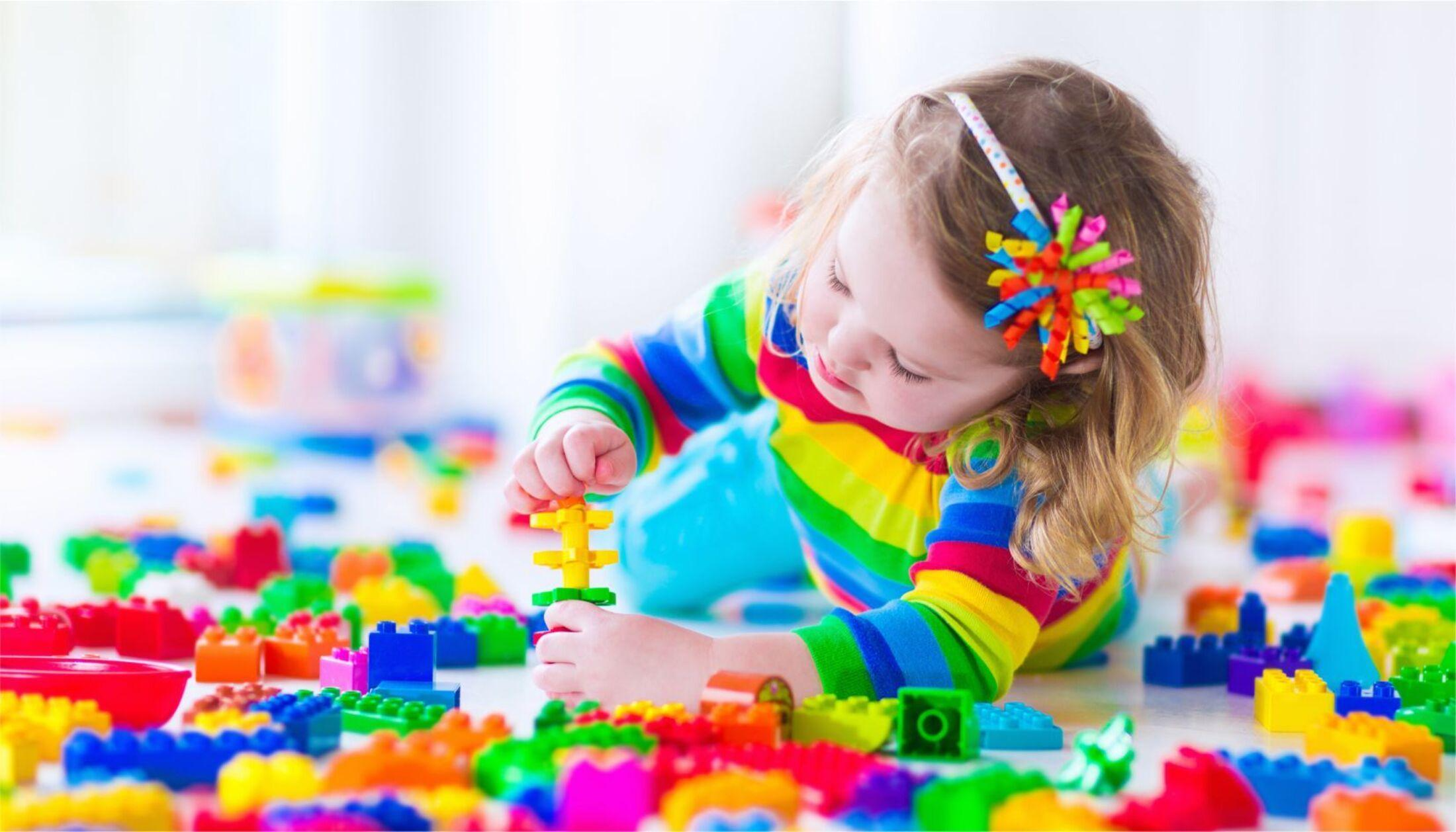 A small child playing with rainbow legos