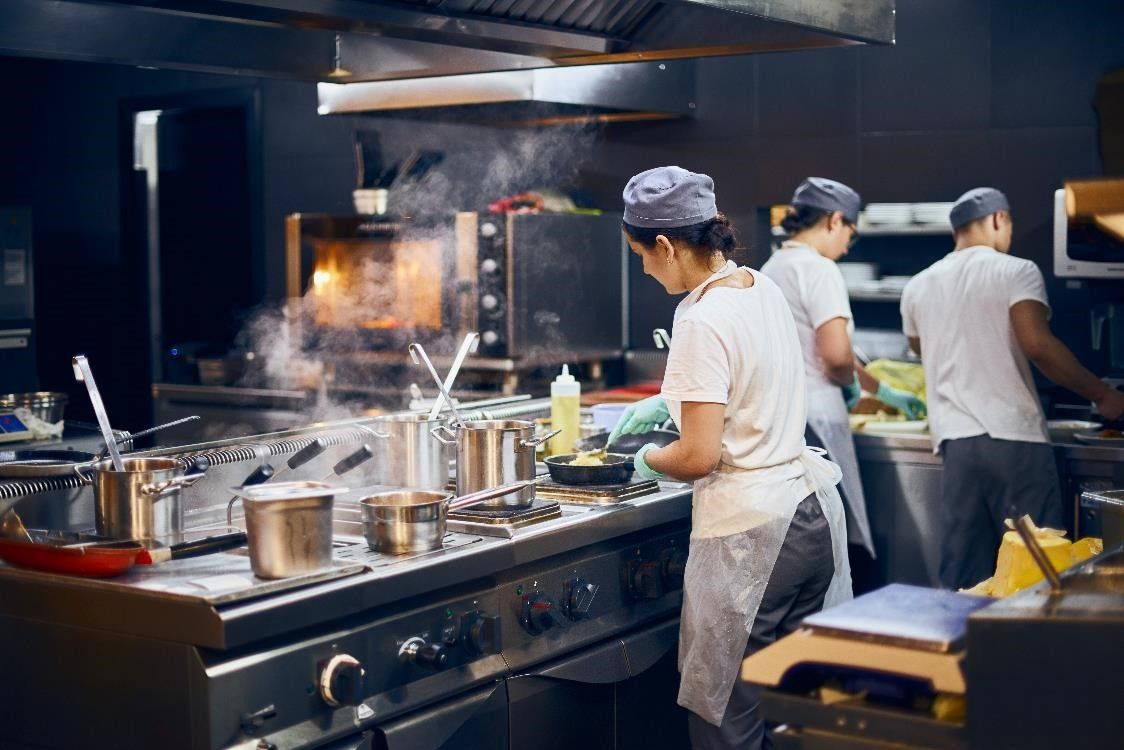 A group of chefs cooking in a kitchen
