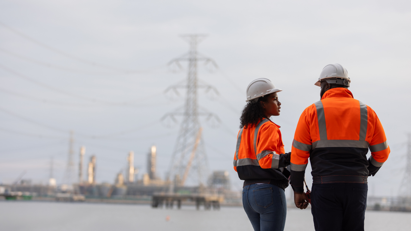 Two people talking in high vis orange jackets