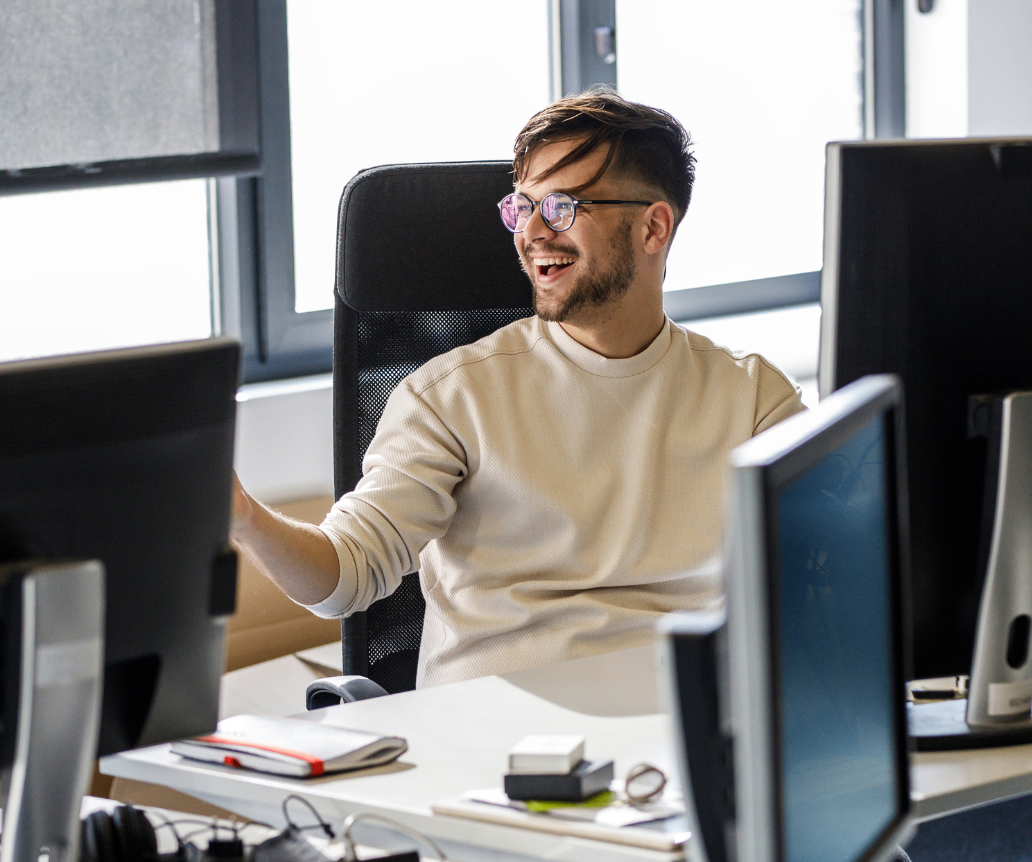 AI engineer working at desktop whilst looking at salary guide