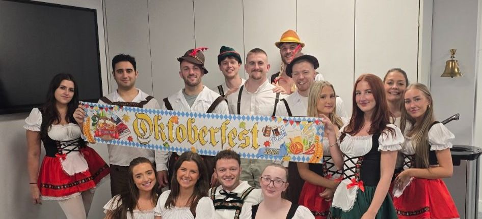 Diverse Pareto team members celebrating Oktoberfest in traditional costume in the office.