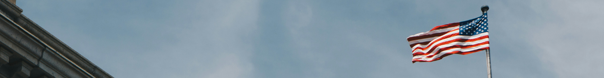 American flag flying on a flagpole against a blue sky