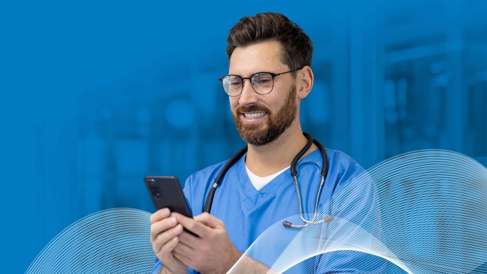 A doctor looking to his mobile phone ready to send a message to Global Medics' team