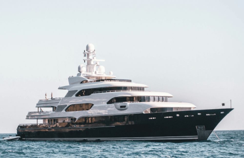 Large luxury superyacht sailing on open water under clear skies.
