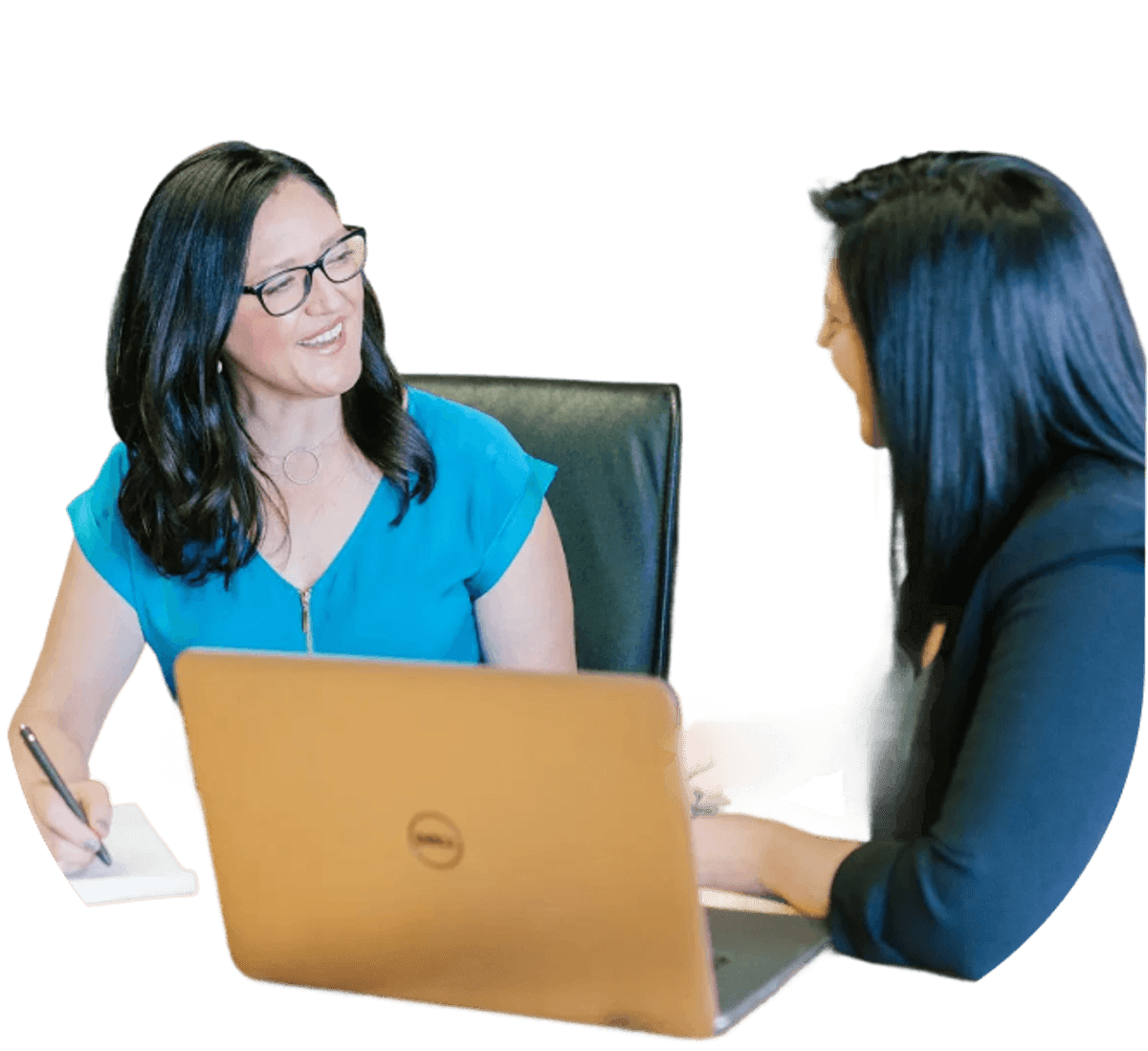 Two people seated at a desk with a laptop open between them, discussing notes in a professional setting.