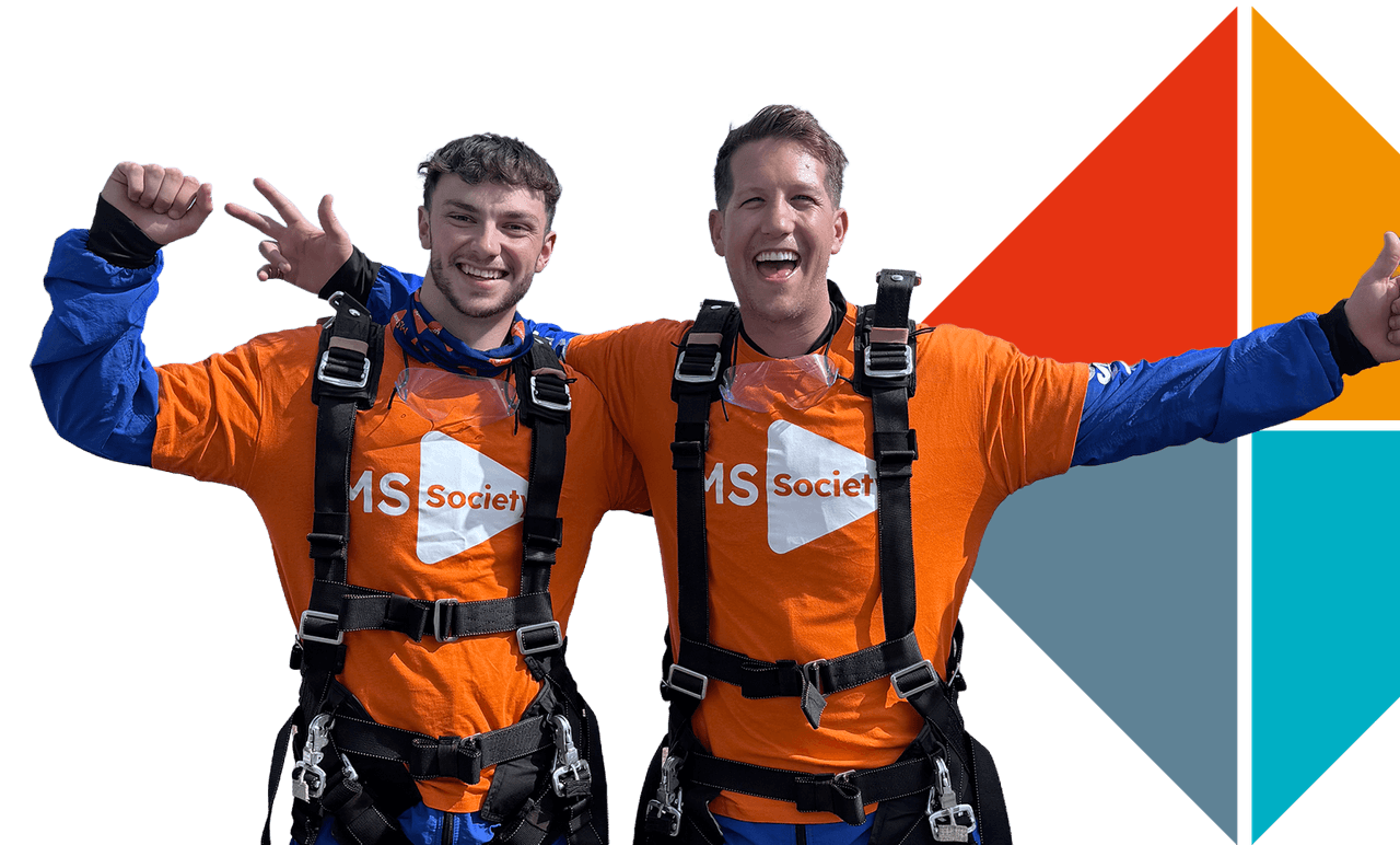Zwei Mitarbeiter von Rise Technical in gesponserten orangefarbenen MS-Society-Shirts lächeln und posieren