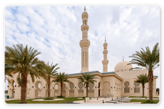 Elegant mosque with domes and minarets surrounded by palm trees