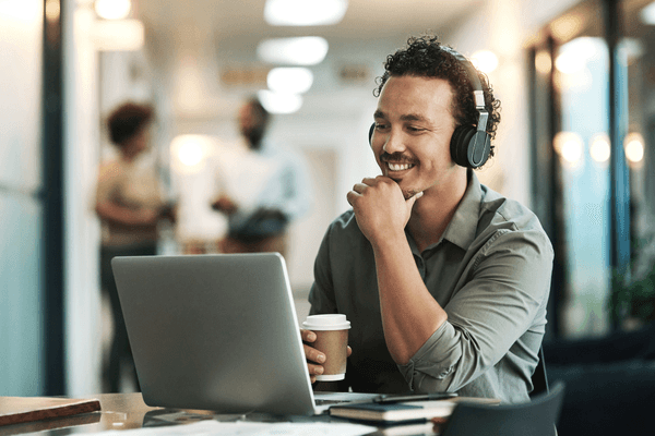 BI professional looking at salary data on laptop with headphones