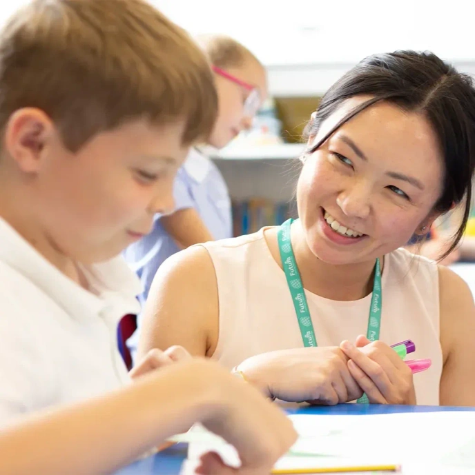 Female teacher smiling at a pupil