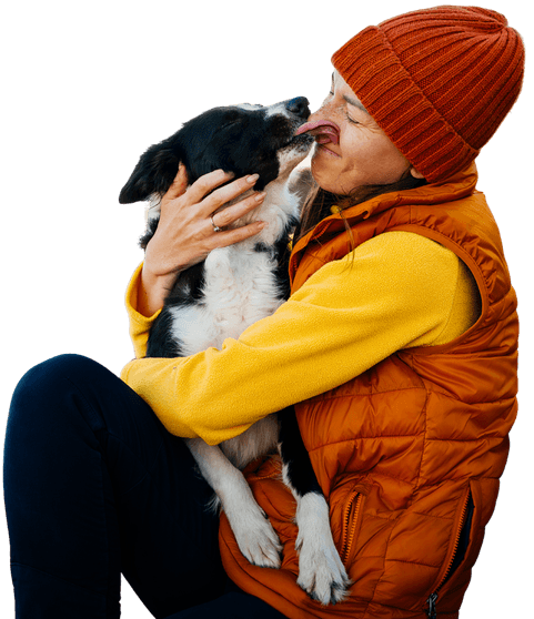 Person sitting with a dog in a warm, affectionate moment, symbolising wellbeing, companionship and emotional support.