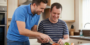 A Support Worker chopping vegetables with an adult in a learning disability service