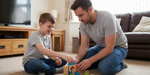 Male Support Worker with a young boy playing with buildable bricks