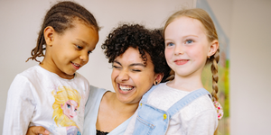 Support Worker smiling with two children she cares for 