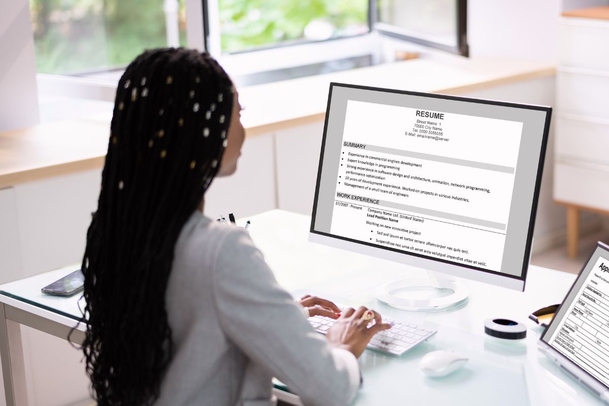 Professional looking at computer planning job search strategy in August