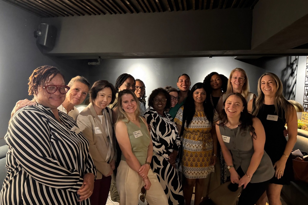 A group of women pose together at a Women Building Bio networking event in a modern venue. Attendees from a range of biotech and pharmaceutical backgrounds smile for a group photo, reflecting the community's focus on connection, collaboration, and supporting women across the life sciences industry.