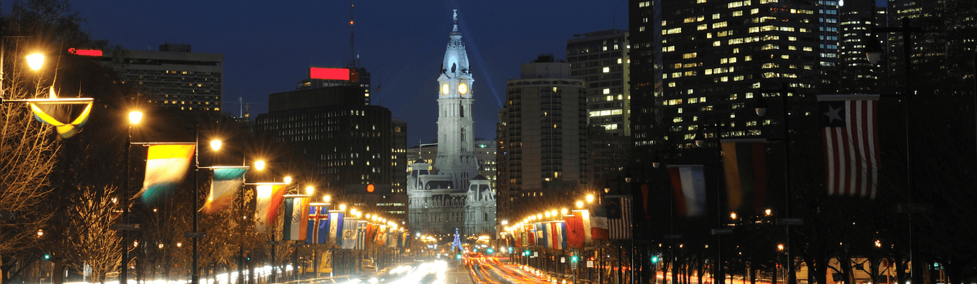 A bustling street in Philadelphia adorned with bright lights, capturing the energy and charm of the city after dark.