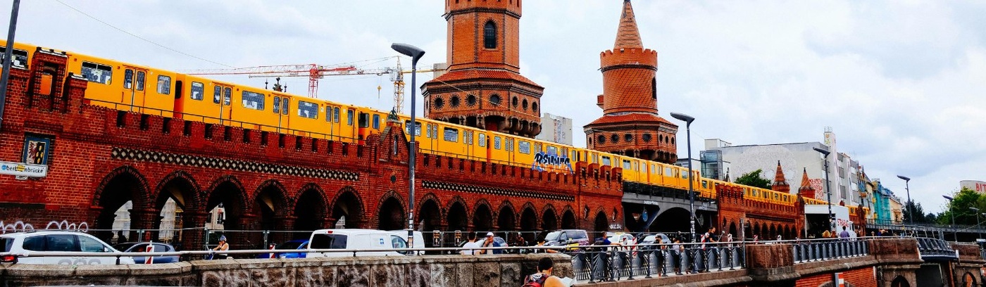  A train runs on tracks next to a building in Berlin, illustrating the integration of rail transport in the urban landscape.