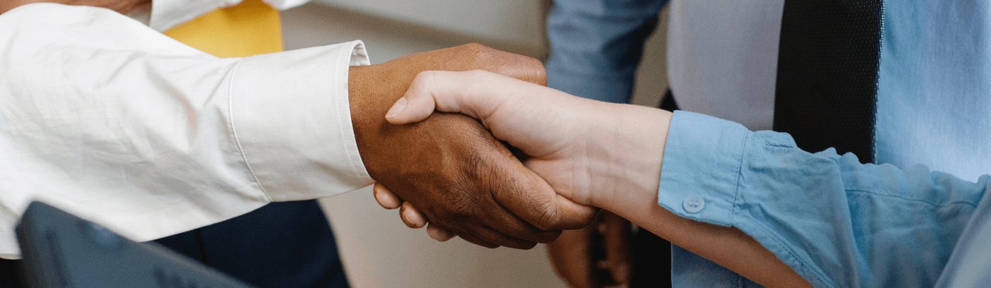 A meeting scene featuring two people shaking hands, representing a successful negotiation or partnership.