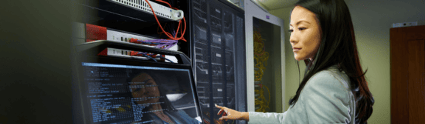 A businesswoman in a tailored suit diligently working on her laptop, showcasing a professional work environment.