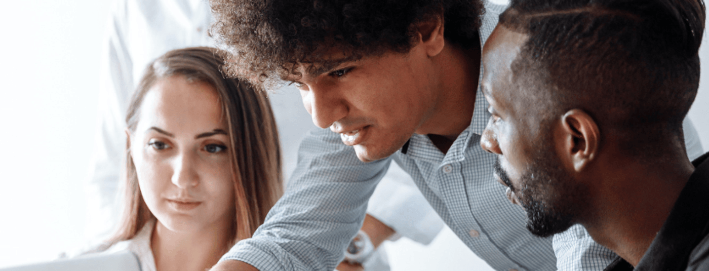 Several people gathered around a laptop, actively working together and exchanging thoughts in a collaborative environment.