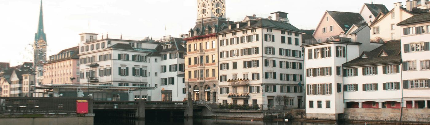 A serene body of water reflecting the sky, surrounded by lush greenery and distant hills, evoking tranquility and peace.