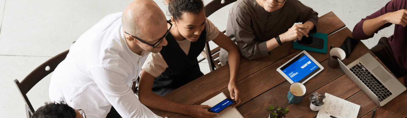A group of diverse individuals engaged in conversation in a modern office setting.
