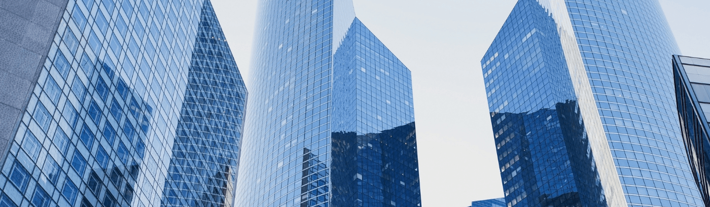 A skyline view of modern tech buildings with large windows reflecting sunlight.