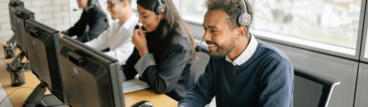 A diverse group of professionals collaborating on computers in a modern office environment.