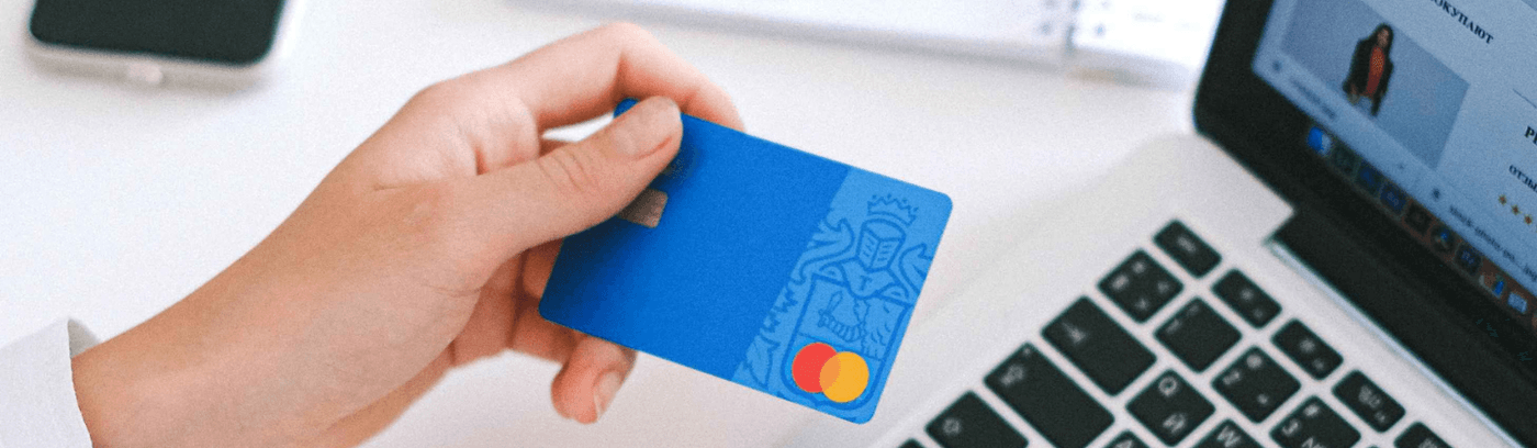 Individual with a credit card, representing fintech, focused on improving the success of their online store.