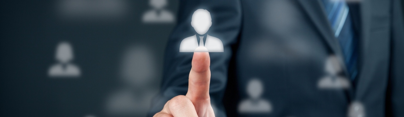 A businessman gestures towards a person icon on a screen, highlighting the importance of personal connection in business.