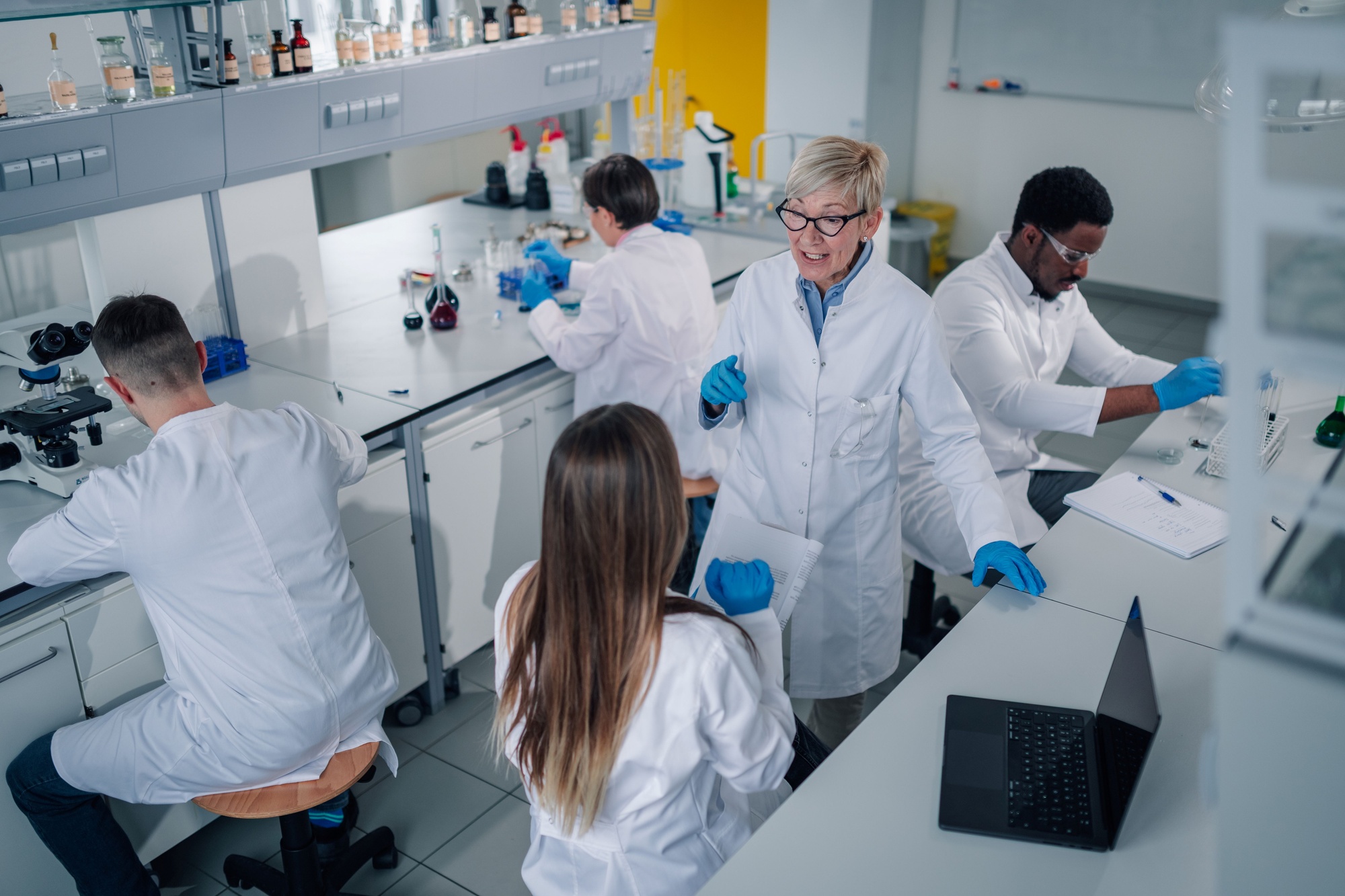 Experienced scientist guiding students in a laboratory