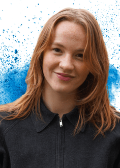 Girl smiling with blue paint splash in background
